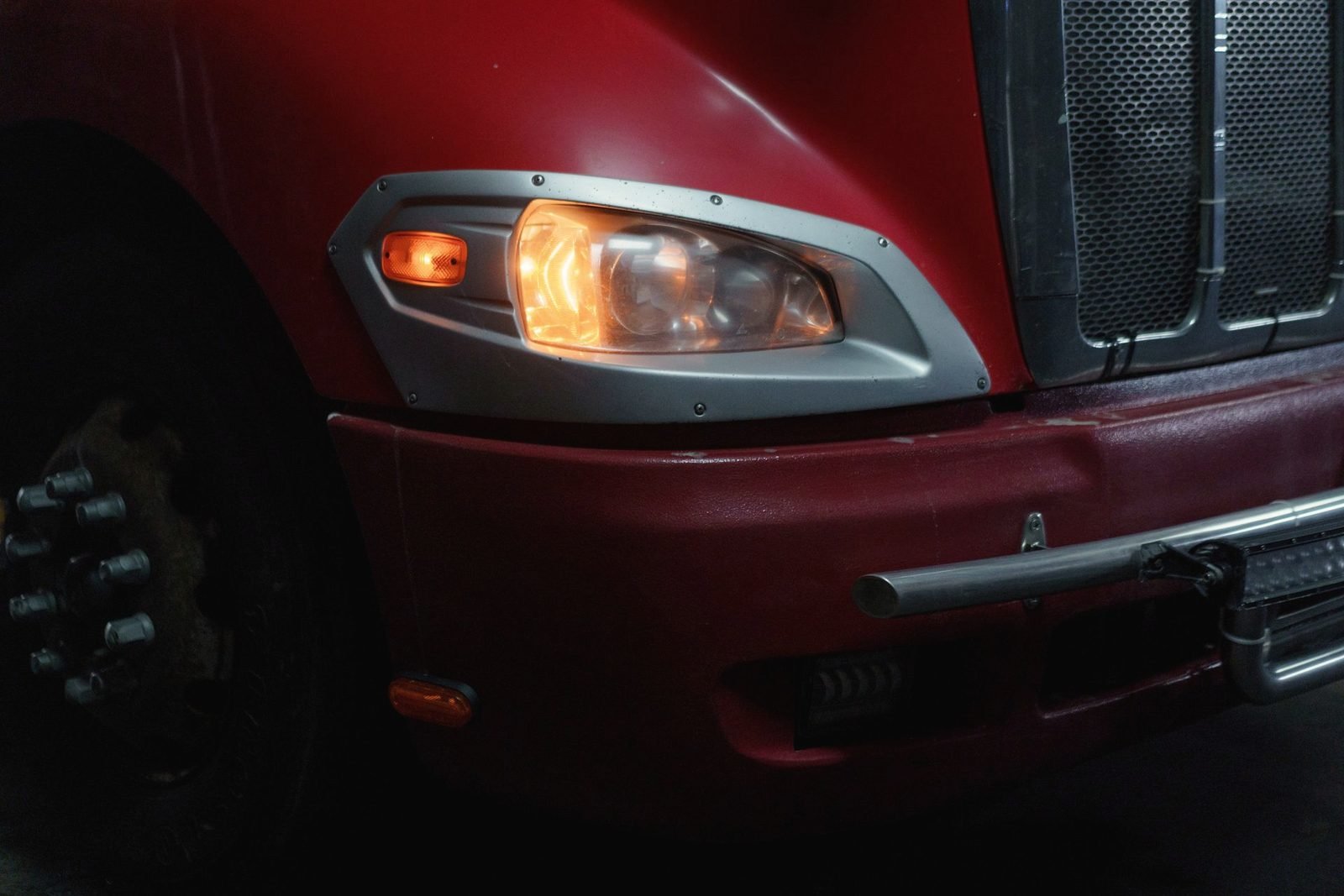 Close view of an amber headlamp on a red tractor